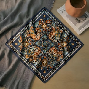 May include: A navy blue square scarf with an intricate paisley pattern in shades of orange, blue, and white. The scarf features a detailed floral design and a decorative border. This accessory is suitable for various styles.