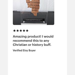 May include: A framed, ancient papyrus fragment with visible text. The papyrus is a light brown color and is displayed against a white background. The image includes the text "Amazing product! I would recommend this to any Christian or history buff."