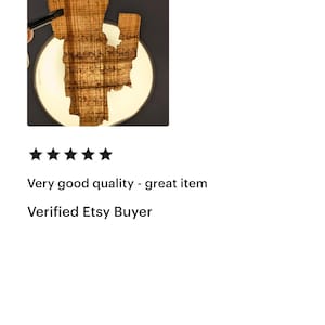 May include: A wooden art piece in the shape of a state, possibly Louisiana, is displayed on a white circular surface against a dark background. The wood has a natural, textured grain. The text "Very good quality - great item" and "Verified Etsy Buyer" are also visible.