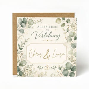 Op de afbeelding: Een vierkante verlovingskaart met een bruine envelop. De kaart heeft een aquarelrand van eucalyptus en gipskruid, de tekst ALLES LIEBE zur Verlobung, de namen Chris & Luisa in goud en twee kleine gouden in elkaar grijpende ringen.