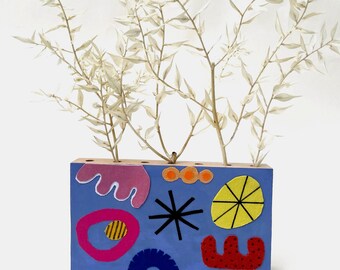 Handmade wooden vase of dried flowers, with acrylic paint and appliquéd fabric elements as table decoration, dopamine and retro trend
