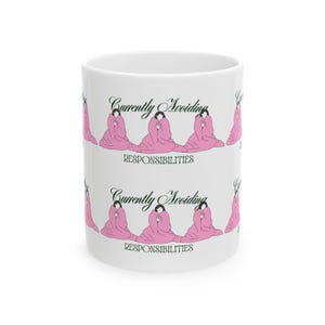 May include: A white ceramic mug featuring a repeating graphic of a person wrapped in a pink blanket. The text "Currently Avoiding" appears in black script above the figure, with the word "RESPONSIBILITIES" in black block letters below it.