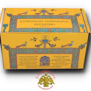 Può includere: Una scatola gialla con un bordo dorato e disegni intricati. La scatola è etichettata "Karvounaki Thymiamatos Byzantino" e presenta una rappresentazione di un pavone e di una fontana. La scatola è realizzata da Panagia Nioras.