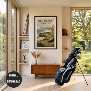 May include: A framed poster titled DOONBEG WILD ATLANTIC LINKS depicting a coastal golf course, hanging above a wooden cabinet. To the right stands a navy blue and white TaylorMade golf bag with clubs. A small golf figurine sits on a shelf.