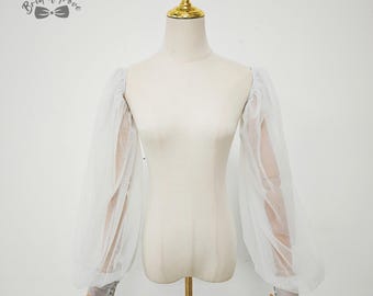 May include: White sheer bridal sleeves with long, voluminous puff sleeves. The sleeves are displayed on a mannequin with a gold-colored stand. The brand name "Bridal Trove" is visible in the upper left corner.