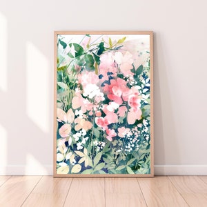 Op de afbeelding: Ingelijste aquarelprint met bloemen in roze, witte en groene tinten. Het bloemkunstwerk is geplaatst tegen een donkerblauwe achtergrond, met een houten frame. De print wordt gepresenteerd op een lichtgekleurde muur.