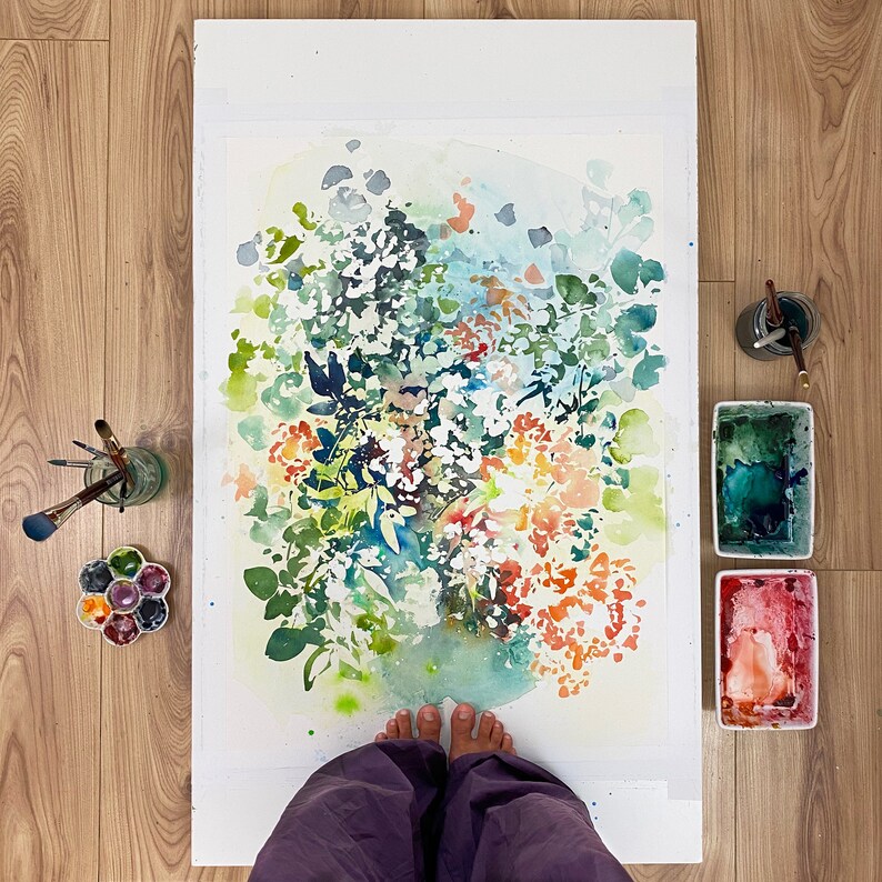 May include: A watercolor painting of a floral bouquet with green leaves and orange, pink, and white flowers. The painting is on a white background and is framed by a white mat.