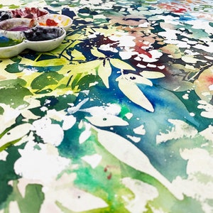 May include: A close-up of a watercolor painting with a green, blue, and white abstract pattern. The painting has a textured, splattered look, and the colors are vibrant and bold.