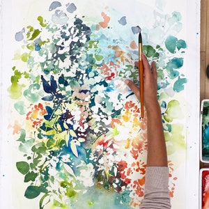 May include: A watercolor painting of a floral bouquet with a brush and hand holding the brush. The flowers are painted in shades of red, orange, yellow, green, and blue. The background is white.