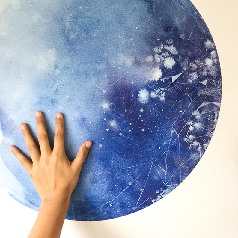 May include: A blue and white watercolour painting of a moon with a geometric pattern. The moon is painted in shades of blue, with white stars and a geometric pattern in white.