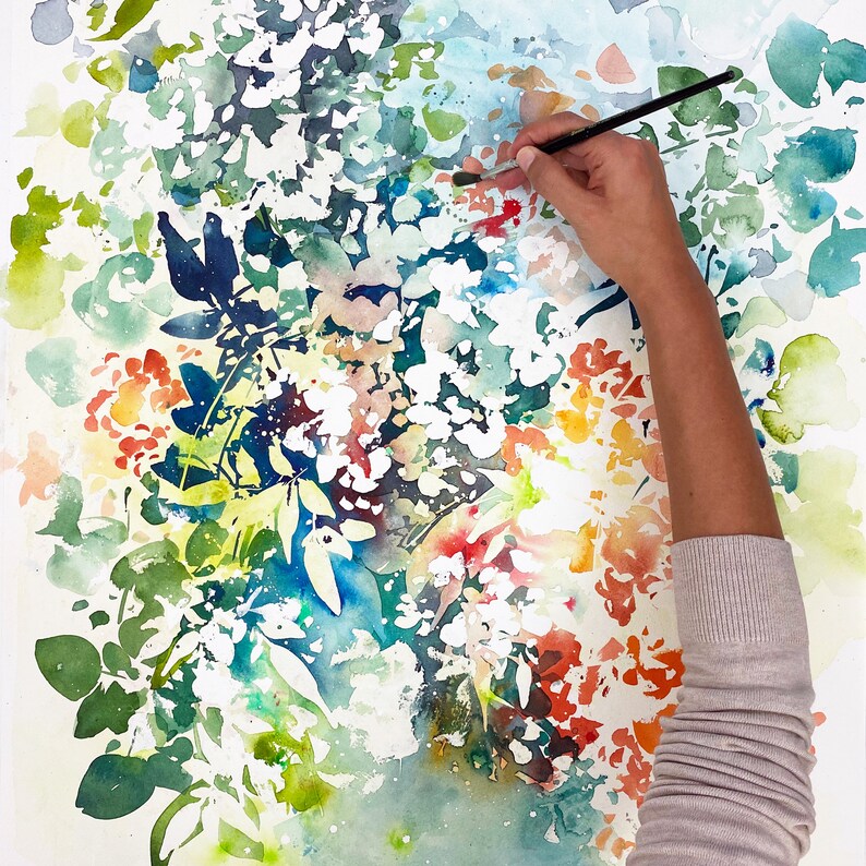 May include: A watercolor painting of a floral arrangement with a hand holding a paintbrush. The flowers are in shades of red, orange, yellow, and white. The background is a light blue and green.