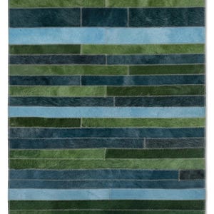 Peut inclure: Un tapis rectangulaire composé de bandes horizontales en peau de vache dans des tons variés de bleu foncé, vert forêt et bleu ciel clair. Les pièces de cuir individuelles sont assemblées par des coutures en zigzag grises.