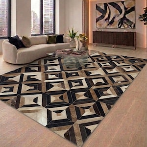 May include: A large rectangular area rug featuring a geometric pattern composed of alternating black, white, and brown panels. The design consists of repeating square and diamond shapes arranged in a grid, creating a textured, multi-tonal appearance.