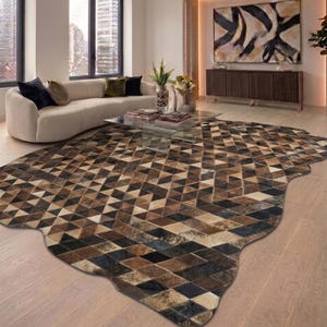 Könnte beinhalten: Ein großer, geometrisch gemusterter Teppich in Braun-, Beige- und Schwarztönen dominiert den Vordergrund. Das Design des Teppichs weist ein sich wiederholendes Rautenmuster auf. Der Teppich liegt auf einem hellen Holzboden in einem modernen Wohnzimmer.