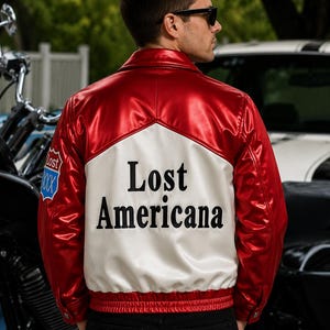 May include: A shiny red and white bomber jacket featuring a collar, long sleeves, and a ribbed hem. The back displays the text Lost Americana in black lettering. A small blue and red patch with the text Lost XXX is visible on the right sleeve.