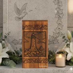 Pode incluir: Urna de madeira castanha com uma cena de farol esculpida, ondas e uma lua crescente. A urna tem volutas decorativas e o texto "Artshulas". Uma vela acesa e flores brancas ao fundo.