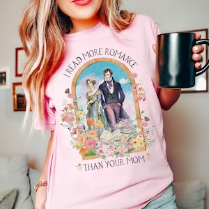 May include: Pink t-shirt with a floral design and the text "I read more romance than your mom".