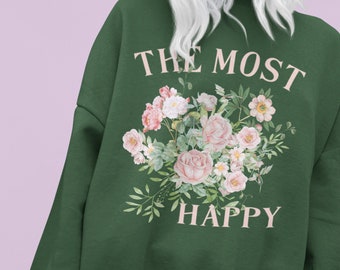 May include: Green sweatshirt with a floral design and the text "THE MOST HAPPY" in pink.