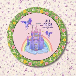 May include: Circular decorative item with a pink centre featuring a purple castle, rainbow, and dragons. The text "ALL PRIDE no prejudice" is displayed. The border is green with yellow and pink flowers.