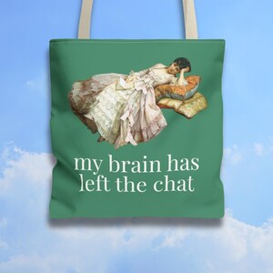 Può includere: Borsa tote verde con un dipinto vintage di una donna sdraiata su cuscini, che tiene un libro. Il testo "my brain has left the chat" è stampato in bianco. La borsa ha cinghie beige.