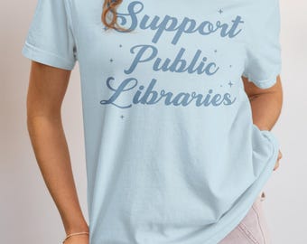 May include: A light blue t-shirt with the text "Support Public Libraries" in a blue script font.