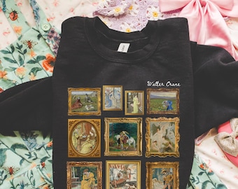 Puede incluir: Sudadera negra con nueve pinturas enmarcadas con bordes dorados. El texto "Walter Crane" está impreso en blanco sobre las pinturas. La sudadera se muestra sobre una superficie con estampado floral.