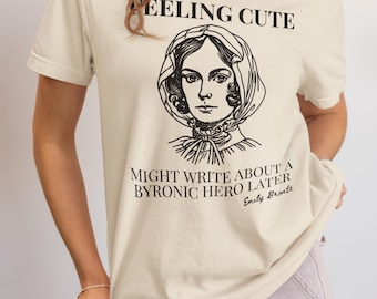 Könnte beinhalten: Ein beiges T-Shirt mit einem schwarzen Grafikdruck einer Frau mit dem Text "Feeling Cute. Might write about a Byronic hero later. Emily Bronte."