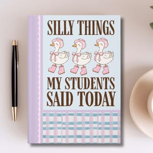 May include: A notebook with the text "SILLY THINGS MY STUDENTS SAID TODAY" and illustrations of three ducks wearing pink hats and boots. The notebook has a light blue and pink plaid pattern at the bottom.