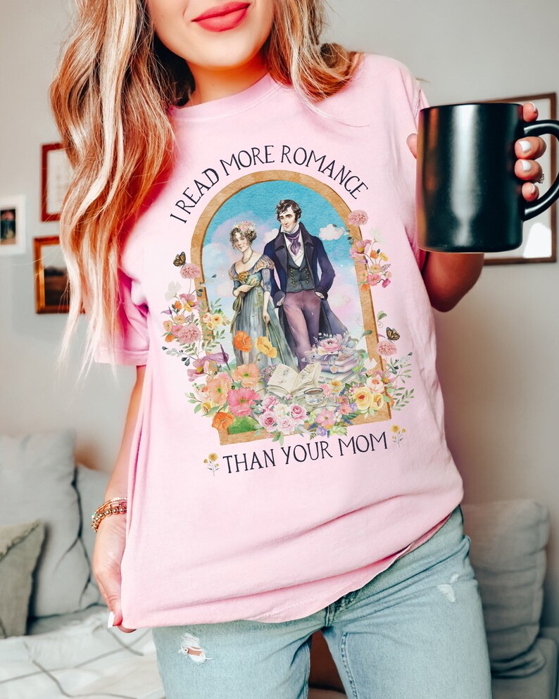 May include: Pink t-shirt with a floral design and the text "I read more romance than your mom".