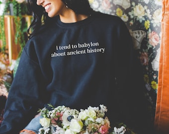 May include: A black sweatshirt with the text "i tend to babylon about ancient history" printed in white on the front.
