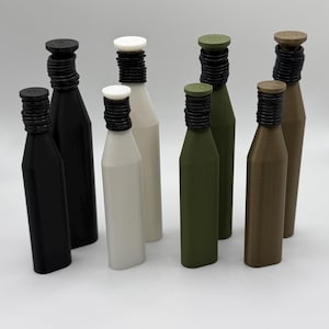 May include: A collection of eight bottles in various colors, including black, white, olive green, and brown. Each bottle has a black, ridged neck and a matching cap. The bottles are arranged on a white surface.