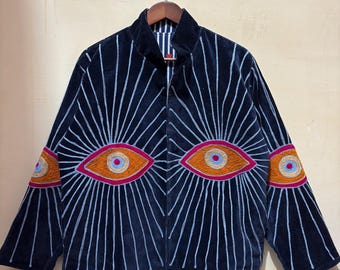 May include: Navy blue velvet jacket with embroidered eye designs in orange, pink, and blue. The jacket features a high collar and vertical white lines radiating from the eyes. The sleeves also have eye designs.