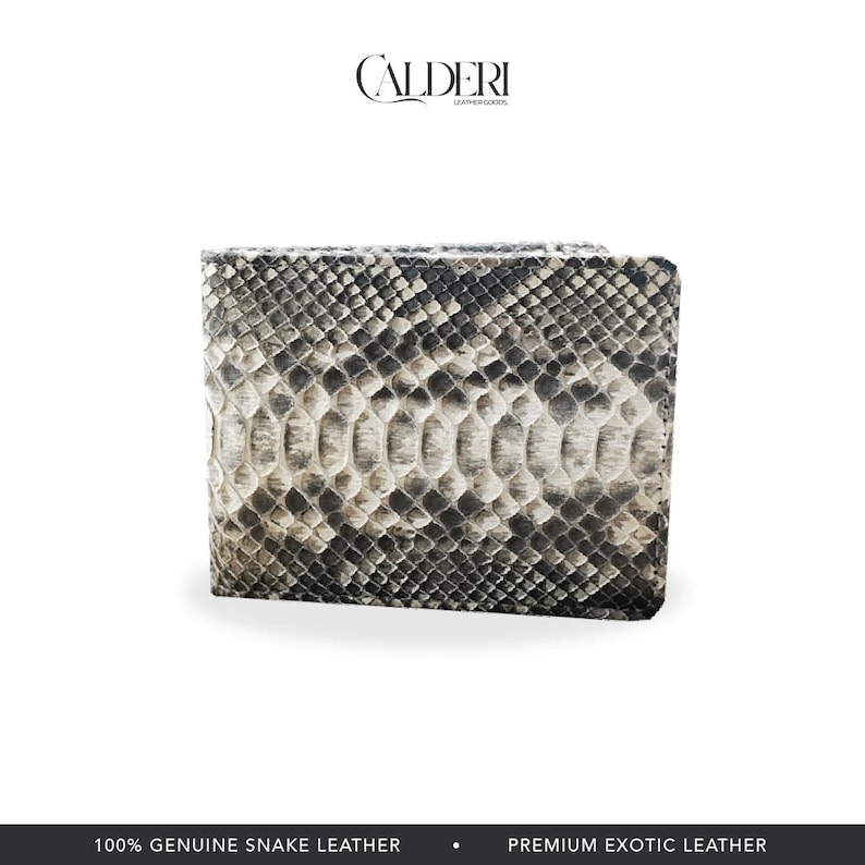 May include: A bi-fold wallet made of genuine snake leather. The wallet features a pattern of black, gray, and white scales. The brand name "CALDERI" is displayed at the top. The bottom of the image reads "100% GENUINE SNAKE LEATHER" and "PREMIUM EXOTIC LEATHER."