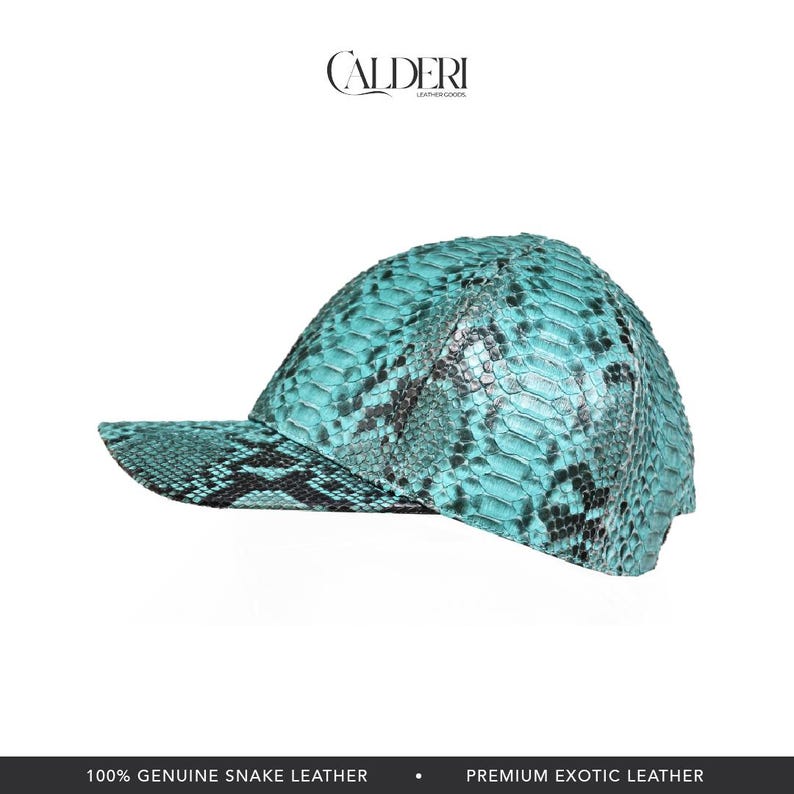 May include: A turquoise baseball cap with a snakeskin pattern. The cap is made of genuine snake leather and features the brand name "CALDERI" in a serif font. The cap has a curved peak and a structured crown.