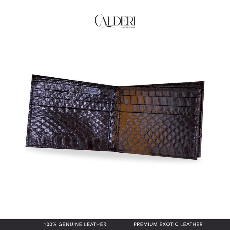 May include: Open, dark brown leather wallet with a crocodile skin texture. The wallet has multiple card slots and a bill compartment. The brand name "CALDERI" is visible at the top. The bottom of the image reads "100% GENUINE LEATHER" and "PREMIUM EXOTIC LEATHER."