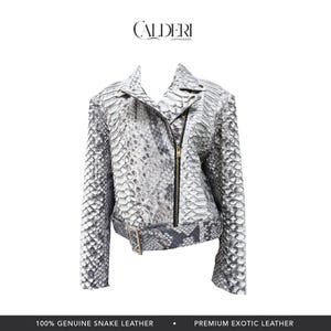 May include: A white and gray snake leather jacket with a zipper closure and a belt. The jacket has a classic biker style with a notched collar and long sleeves. The brand name "CALDERI" is at the top.
