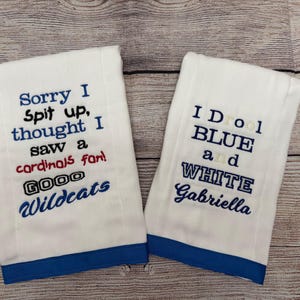 May include: Two white hand towels with blue trim and embroidered text. One says "Sorry I Spit up, thought I saw a cardinals fan! GOOD Wildcats." The other says "I Drool BLUE and WHITE Gabriella."