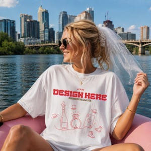 Może przedstawiać: Biały t-shirt z krótkim rękawem z czerwonym napisem graficznym YOUR DESIGN HERE oraz PRIMEPIXELMUSE, uzupełniony czerwonymi rysunkami liniowymi przedstawiającymi butelkę szampana, pierścionek z diamentem, kartę do gry oraz różne nakrycia głowy.