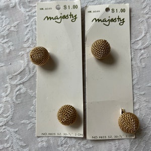 May include: Two cards with gold metal buttons, each with the text "majesty" and "HK. 8046 $1.00". The buttons are 30-3/4 inches in size and are labeled "NO. 9825 SZ. 30-3/4" 2 ON".