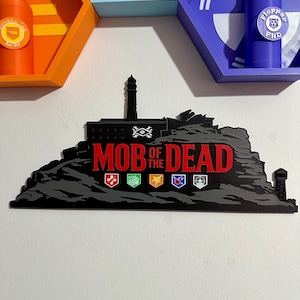 May include: A black and grey Mob of the Dead sign with red text, depicting a prison silhouette with a tower and icons. Above are three hexagonal shelves holding bottles in various colours.