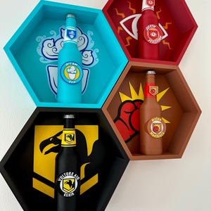 Pode incluir: Quatro prateleiras de parede hexagonais em azul, vermelho, castanho e preto, cada uma contendo uma garrafa com um rótulo único. As garrafas apresentam os rótulos "Who's Who", "Death Perception", "Melee Macchiato" e "Vulture Aid Elixir".