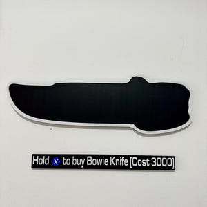 May include: A black Bowie knife silhouette with a white outline is displayed on a white wall. Below the knife, a rectangular sign reads "Hold x to buy Bowie Knife [Cost 3000]" in white text.