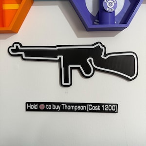May include: Black and white outline of a Thompson submachine gun mounted on a white wall. Below the gun is a black sign with white text that reads "Hold to buy Thompson [Cost 1200]"