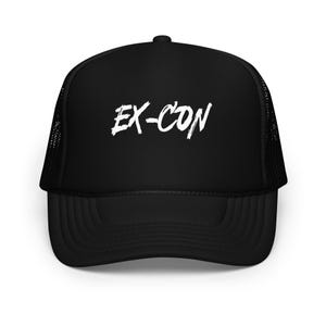 May include: Black trucker hat with a mesh back and a curved brim. The hat features the white text "EX-CON" in a bold, brushstroke style across the front. The hat is a classic accessory.