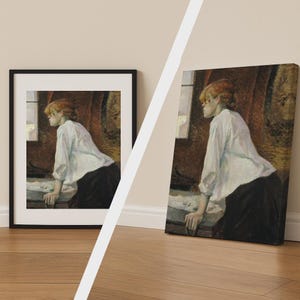 Op de afbeelding: Een ingelijste print en een canvas print van een schilderij. Het kunstwerk toont een vrouw met rood haar in een witte blouse en zwarte rok, leunend op een oppervlak bij een raam. De achtergrond heeft een donker, getextureerd gordijn.