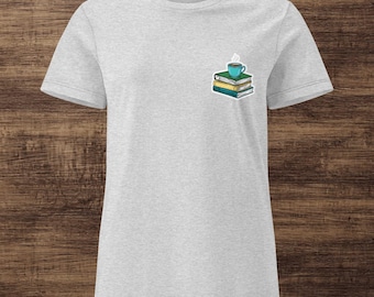 Puede incluir: Camiseta gris claro con un pequeño gráfico de una pila de libros y una taza de café turquesa. Los libros son verdes y amarillos. La camiseta está hecha de un material suave.