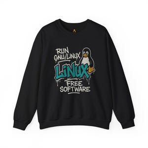 May include: Black sweatshirt with a graphic design featuring a penguin and the words "RUN GNU/LINUX LINUX FREE SOFTWARE" in a graffiti-style font. The penguin is wearing a gold-colored boot. The sweatshirt has long sleeves and a crew neck.
