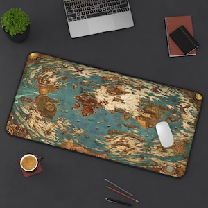 Puede incluir: Una alfombrilla de escritorio rectangular grande con un mapa detallado de estilo antiguo en tonos turquesa, marrón y dorado. Un ratón de ordenador blanco descansa sobre la alfombrilla. Un portátil, una pequeña planta y material de oficina rodean la alfombrilla.