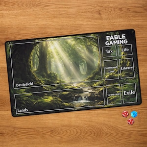 May include: A rectangular gaming playmat featuring a forest scene with a stream, labelled sections for Battlefield, Lands, Tax, Life, Command Zone, Library, Graveyard, and Exile, with the text FABLE GAMING, accompanied by one blue and two red dice.