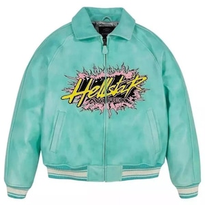 May include: A turquoise bomber jacket with a zip-up front and a collared neckline. The jacket features the text "Hellstar" in yellow and black, surrounded by a pink and yellow flame design. The jacket has white and light blue striped cuffs and hem.